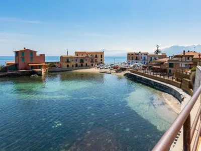 a body of water next to a beach with buildings at Apartment Cicladi Santorini by Interhome in Santa Flavia