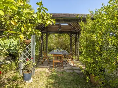 a table and chairs under a pergola in a garden at Apartment Cicladi Mikonos by Interhome in Santa Flavia