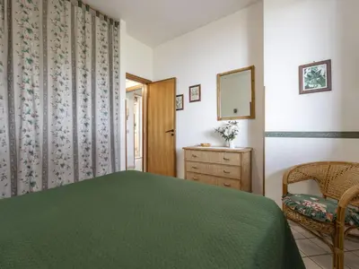 a bedroom with a green bed and a mirror at Apartment Cicladi Amorgos by Interhome in Santa Flavia
