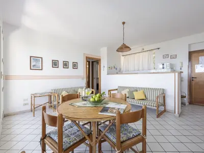 a dining room and living room with a table and chairs at Apartment Cicladi Paros by Interhome in Santa Flavia