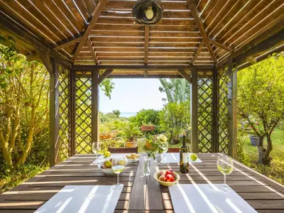 a wooden table in a pergola with food on it at Apartment Cicladi Anafi by Interhome in Santa Flavia