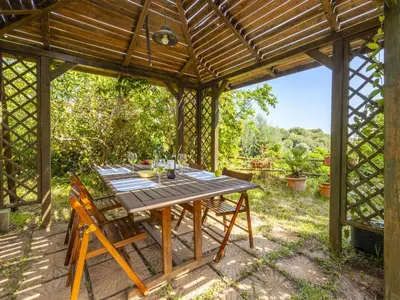 an outdoor dining area with a wooden pergola at Apartment Cicladi Anafi by Interhome in Santa Flavia