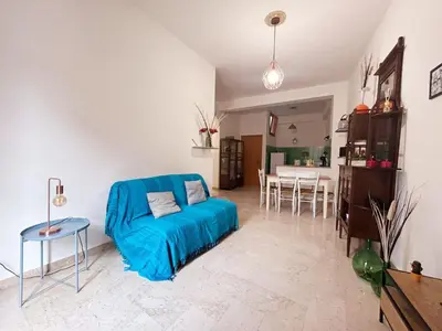 a living room with a blue couch and a dining room at Dai Nonni in Terrasini