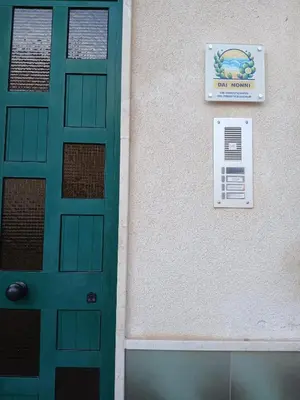 a green door with a sign on the side of a building at Dai Nonni in Terrasini