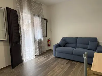 a living room with a blue couch in front of a window at Casa Francesca in Capaci