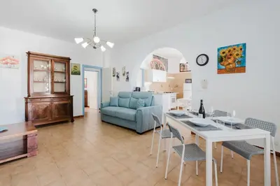 a living room with a table and a blue couch at Archi in Balestrate