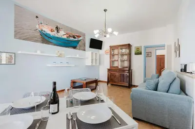 a living room with a table and a blue couch at Archi in Balestrate