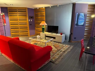 a living room with a red couch and a tv at Amari 124 in Palermo