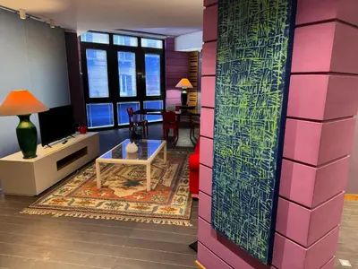 a living room with a pink wall and a table at Amari 124 in Palermo