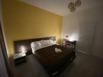 a bedroom with a bed with two white shoes on it at Palazzo Castelli alla Zisa in Palermo