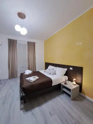a bedroom with a large bed and a yellow wall at Palazzo Castelli alla Zisa in Palermo