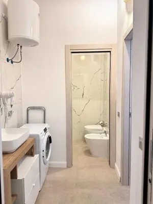 a bathroom with a sink and a washing machine at Helena Apartments - Secondo Canto in Palermo