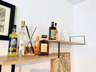 a shelf with bottles of alcohol on a wall at Helena Apartments - Secondo Canto in Palermo