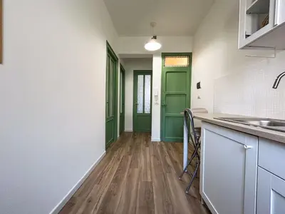 a kitchen with green doors and a wooden floor at MonSea in Palermo