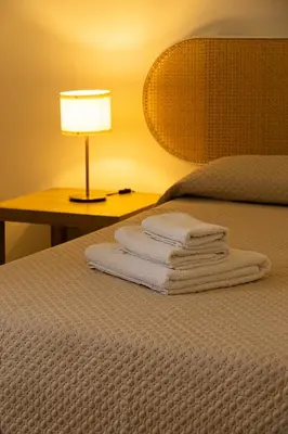 a group of towels on a bed next to a lamp at MonSea in Palermo
