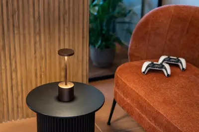 a table next to a chair with a remote control at Le Dimore - Ponte 7 in Palermo