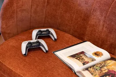 a video game controller and a book on a chair at Le Dimore - Ponte 7 in Palermo