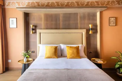 a bedroom with a large bed with yellow pillows at Palazzo De Gregorio - Apartments in Palermo