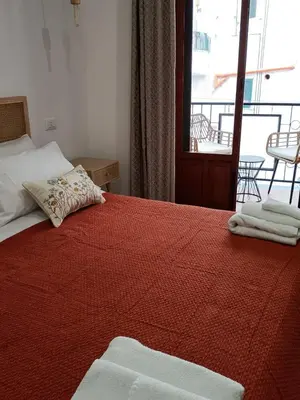 a bedroom with a bed with a red comforter at La Ciconella 2 in Palermo