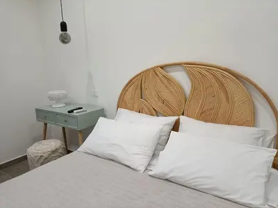 a bed with a wooden head board and white pillows at La Ciconella 2 in Palermo