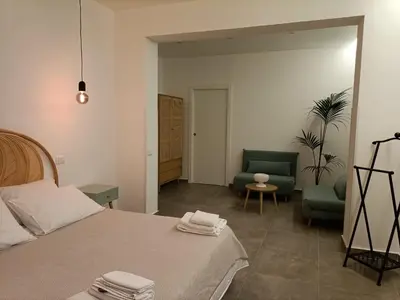 a bedroom with a bed and two chairs in it at La Ciconella 2 in Palermo