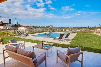 a patio with chairs and a table and a pool at Villa Al-Kurum in Alcamo Marina