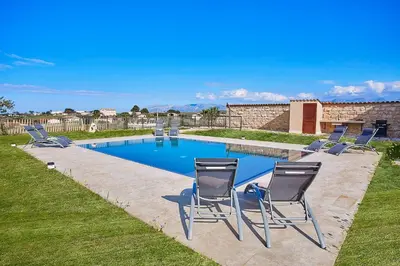 a group of chairs sitting next to a swimming pool at Villa Al-Kurum in Alcamo Marina