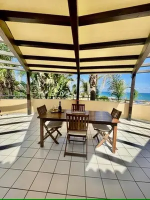 a kitchen with a table and chairs and a refrigerator at Villa Tocco vicino al mare in Balestrate