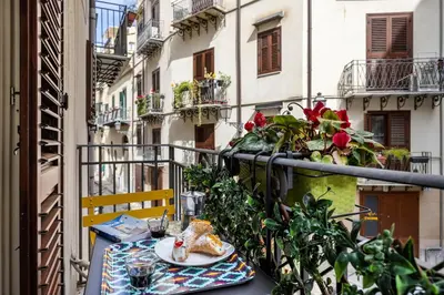 a table with a plate of food on a balcony at Capo Sweet Home in Palermo