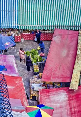 an outdoor market with colorful umbrellas and people selling vegetables at Capo Sweet Home in Palermo