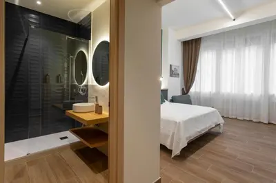 a bedroom with a bed and a glass shower at Marina Rooms - Guesthouse in Palermo