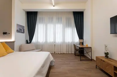 a bedroom with a bed and a desk and a window at Marina Rooms - Guesthouse in Palermo