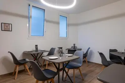 a dining room with tables and chairs and windows at Marina Rooms - Guesthouse in Palermo