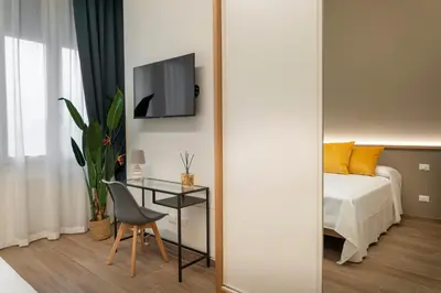 a bedroom with a bed and a table and a mirror at Marina Rooms - Guesthouse in Palermo