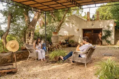 a group of people sitting in chairs under a pergola at Casa Panoramica in Terrasini