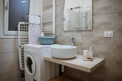 a bathroom with a washing machine and a sink at Residence Salinelle Beach Villa Panarea in Lascari