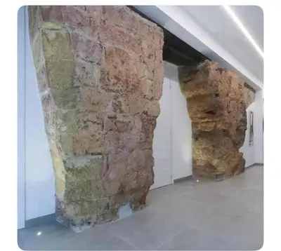 a room with a stone wall next to a building at Genius Loci in Palermo