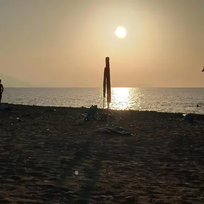 a person standing on the beach at sunset at Villetta al villaggio 101 pini in Campofelice di Roccella