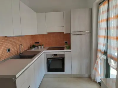 a kitchen with white cabinets and a sink and a dishwasher at Villetta al villaggio 101 pini in Campofelice di Roccella