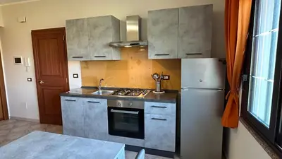 a kitchen with a stainless steel refrigerator and a sink at Casa Punta Barcarello, Sferracavallo fronte mare e tramonti da sogno, a due passi dalla splendida spiaggia di Mondello in Palermo