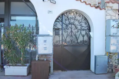 a black door in a white building with plants at Casa Punta Barcarello, Sferracavallo fronte mare e tramonti da sogno, a due passi dalla splendida spiaggia di Mondello in Palermo