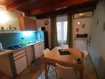a kitchen with a wooden table and a table and chairs at kappa's house a granni in Palermo
