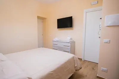 a bedroom with a bed and a tv on the wall at Tribunale Suite in Termini Imerese