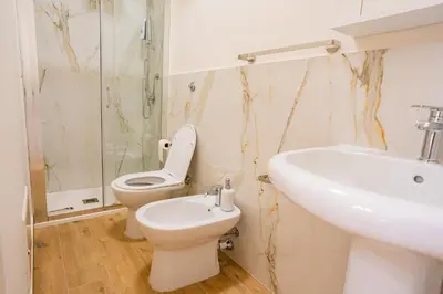 a bathroom with a toilet and a sink at Tribunale Suite in Termini Imerese