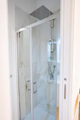 a shower with a glass door in a bathroom at Tribunale Suite in Termini Imerese