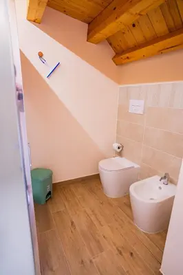 a bathroom with a toilet and a sink at Tribunale Suite in Termini Imerese