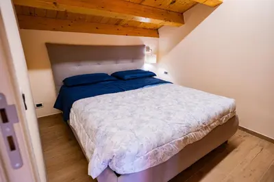 a bedroom with a bed with blue pillows on it at Tribunale Suite in Termini Imerese