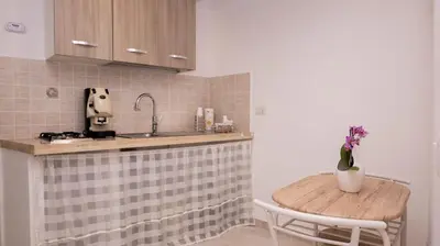 a kitchen with a table with a vase of flowers on it at Leonetti in Carini