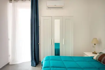 a bedroom with a blue bed and blue curtains at Civico 61 in Palermo