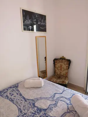 a bedroom with a bed with a mirror and a chair at Loft with terrace in the city centre in Palermo